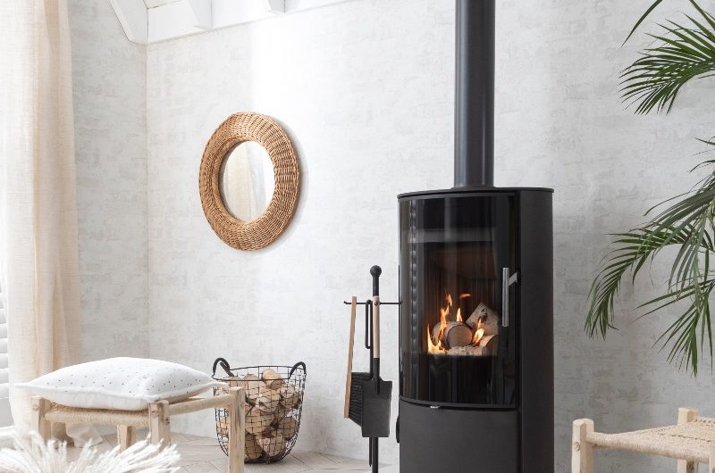 A living room that evokes feelings of warmth and calm with neutral furnishings and a wood fire stove.