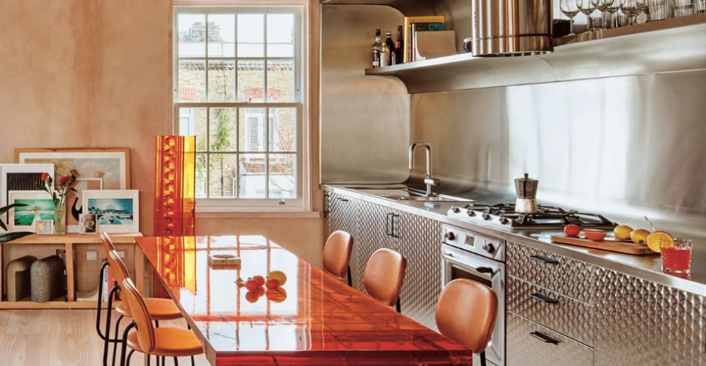 A retro, 70s style kitchen with staineless steel units and quirky decor.