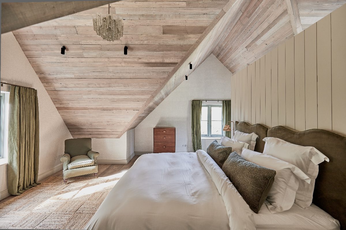 Rustic bedroom design with twin beds, green furnishings, and white linen.