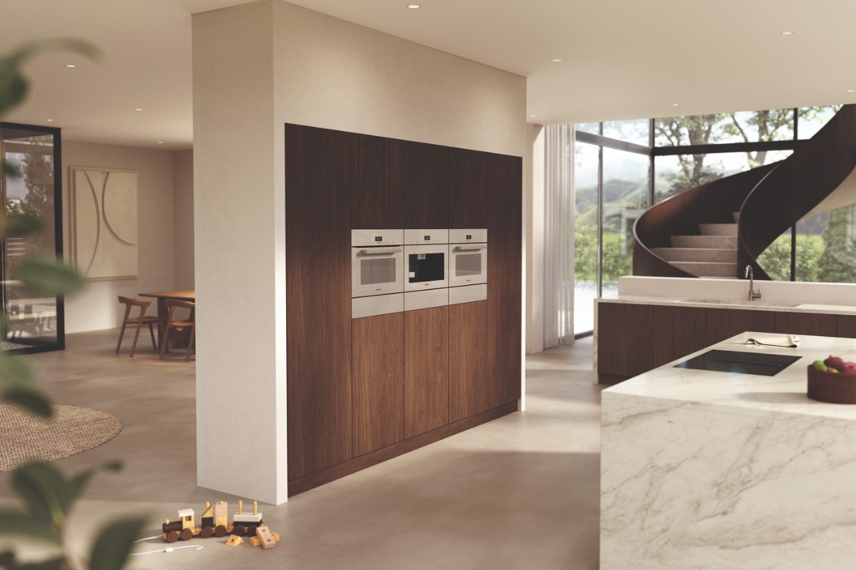Minimalist kitchen with handleless cabinetry, pared-back appliances and a stone clad island.