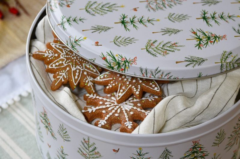 A closeup at a festive cake tin with striped linen fabrics.