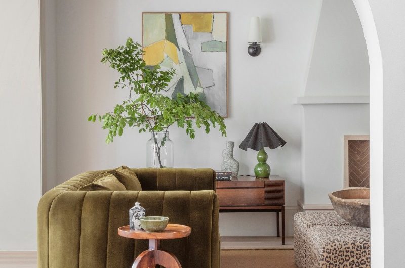 Living room design with a green velvet sofa, a jute rug, and animal-print upholstered coffee table.