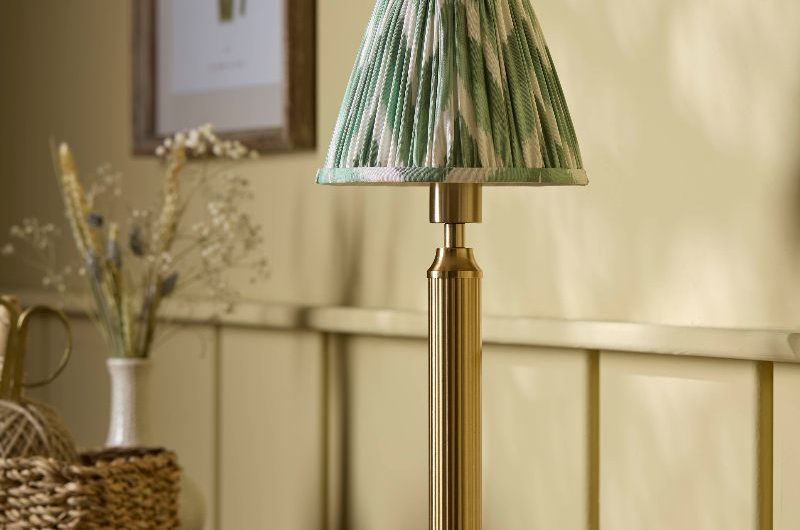 A yellow bedroom with a wood dresser and portable lighting.