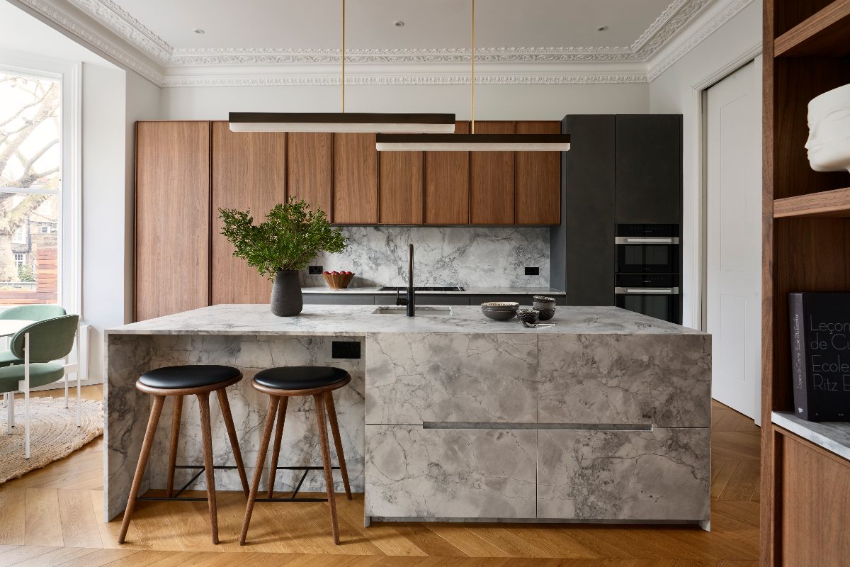 A wood kitchen mixed with dark grey resin cement doors, with a central multi-functional stone-clad island.
