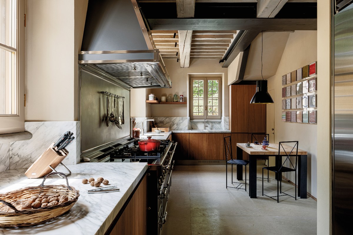 A fusion kitchen with wood cabinets, marble surfaces, stainless steel appliances and a dining zone.