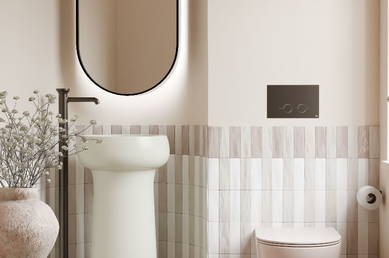 A serene scheme with stacked metro tiles on the wall, terracotta tiles on the floor, a wall-mounted toilet, and a pastel pedestal basin.