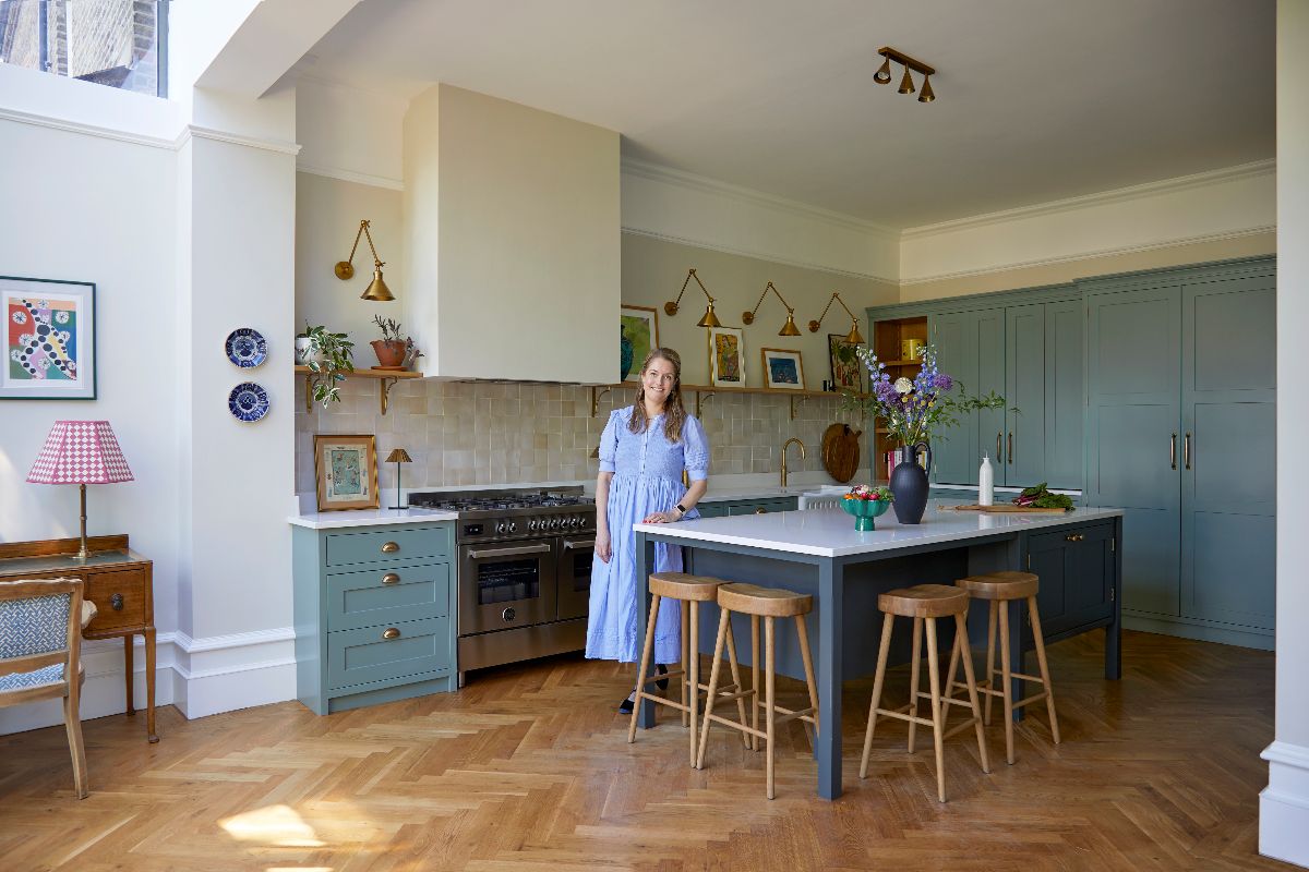 Homeowner posing next to her kitchen island in her newly renovated space.