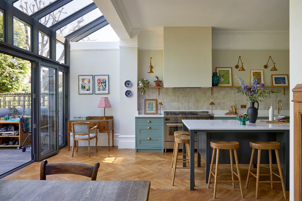 A look at the warm kitchen design from the dining area with glazing on the left leading to the garden.