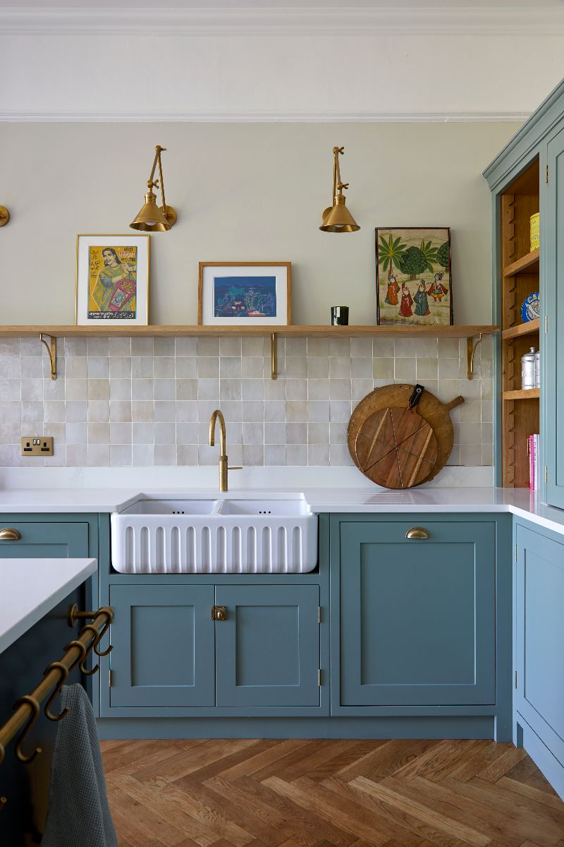 A sink zone with a double butler bowl with a fluted finish, zellige wall tiles, and wood open shelving.