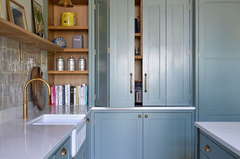 An L-shaped layout with a sink zone, display shelves, and an appliance garage.