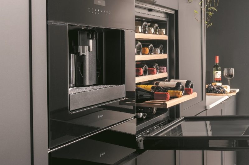 A modern kitchen design with built-in coffee machine and fridge.