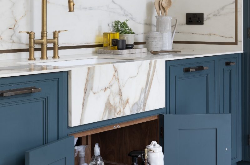 A contemporary kitchen with cleaning essentials in the under-sink cabinet with pull-out trays.