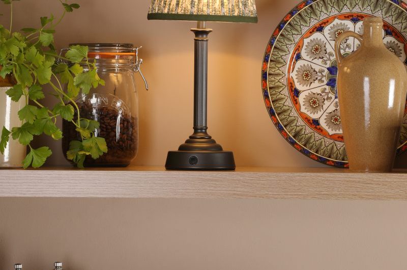 Kitchen design with wood shelves, pale pink wall paint, patterned ceramics, house plants, and wood salt and pepper mills.