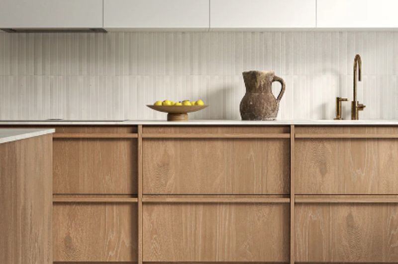 A wood kitchen design with off-white wall cabinets, tiles, and concrete-effect flooring.