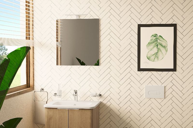 A minimalist bathroom with a vanity unit, patterned flooring, wall-mounted toilet, herringbone metro wall tiles, and wall art.