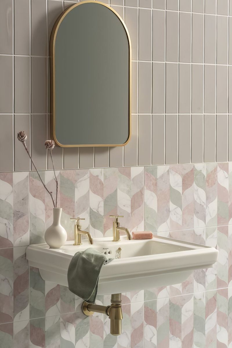 A glamorous bathroom with pastel tones, pedestal basins, Art Deco tiles, and metallic finishes.