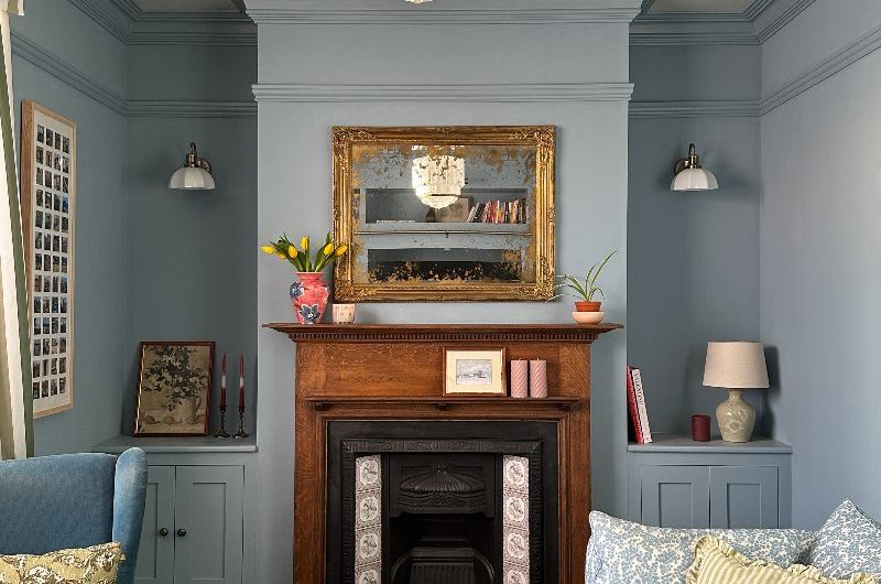 A calm, blue renovated snug with a fireplace and patterned soft furnishings.