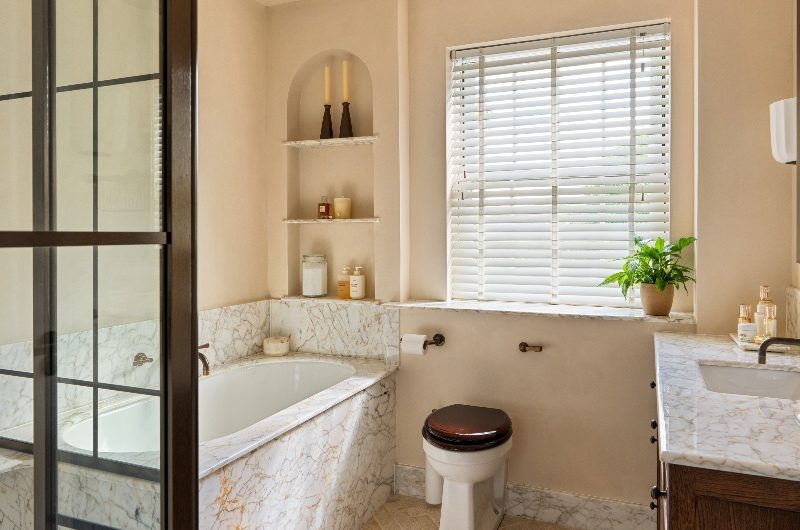View of the ensuite with amber marble, terracotta flooring and wood accents.