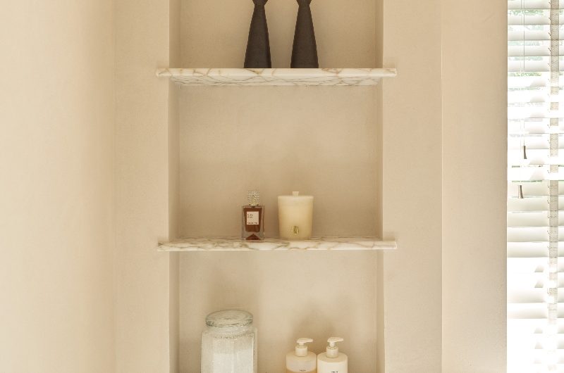 Closeup at a storage niche with amber marble shelves.