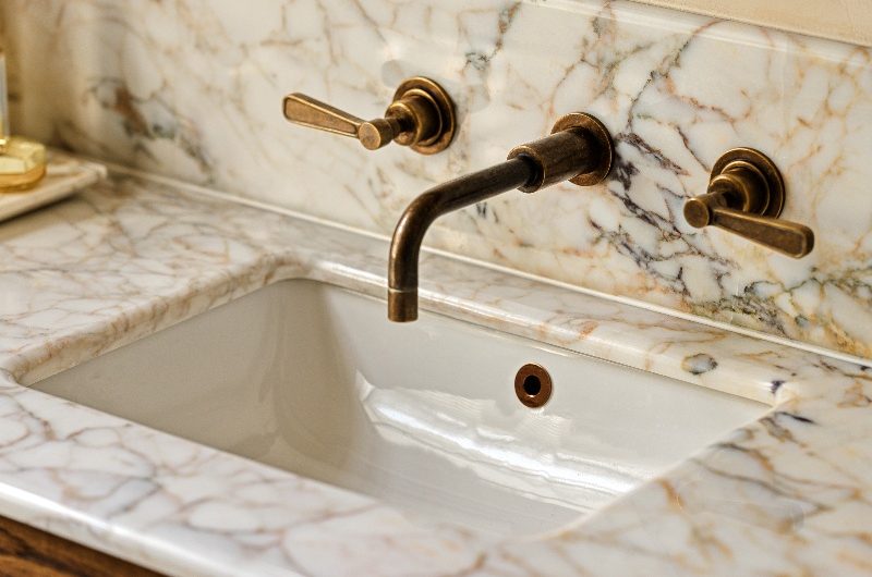 Closeup at the sink and bronze brassware.