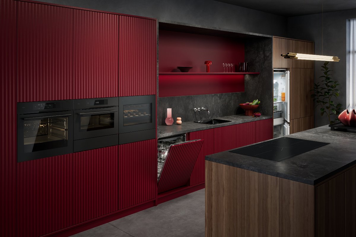 A burgundy red kitchen with sleek built-in appliances, a wood island, and dark stone surfaces.