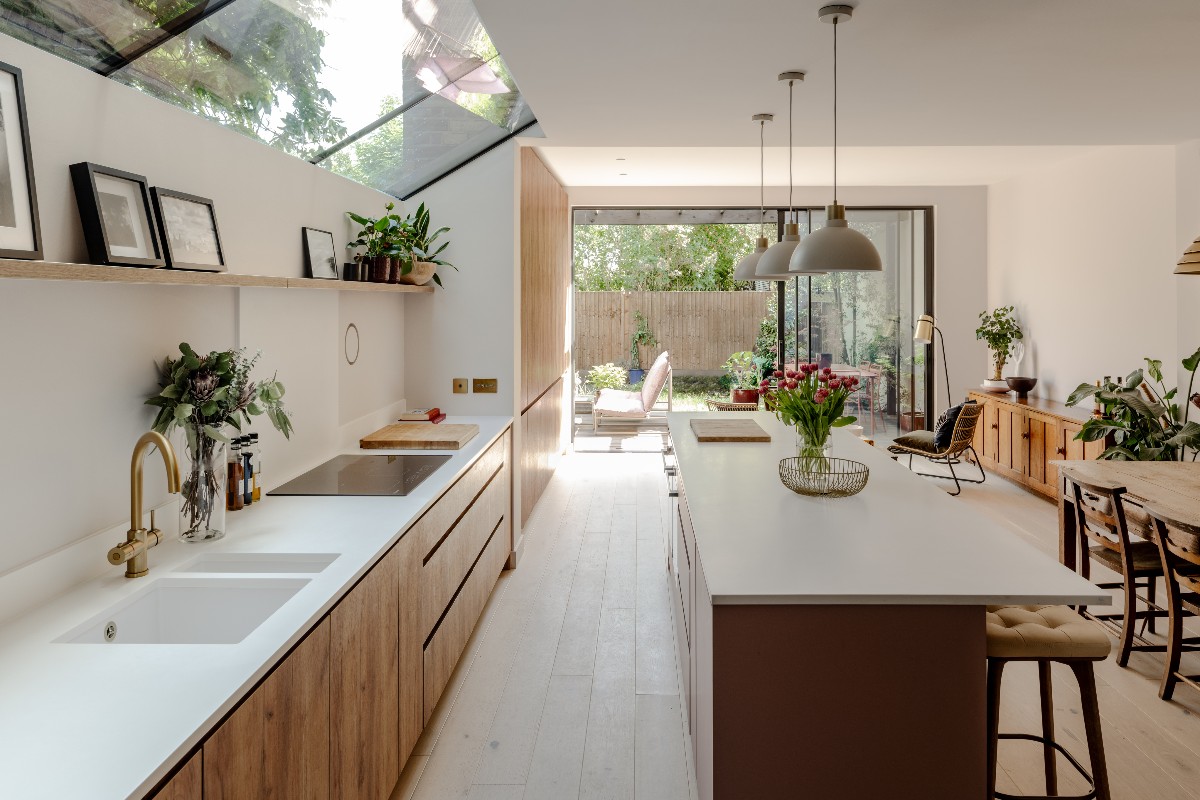 Light floods the space through the glazed roof along the length of the main cabinetry run.