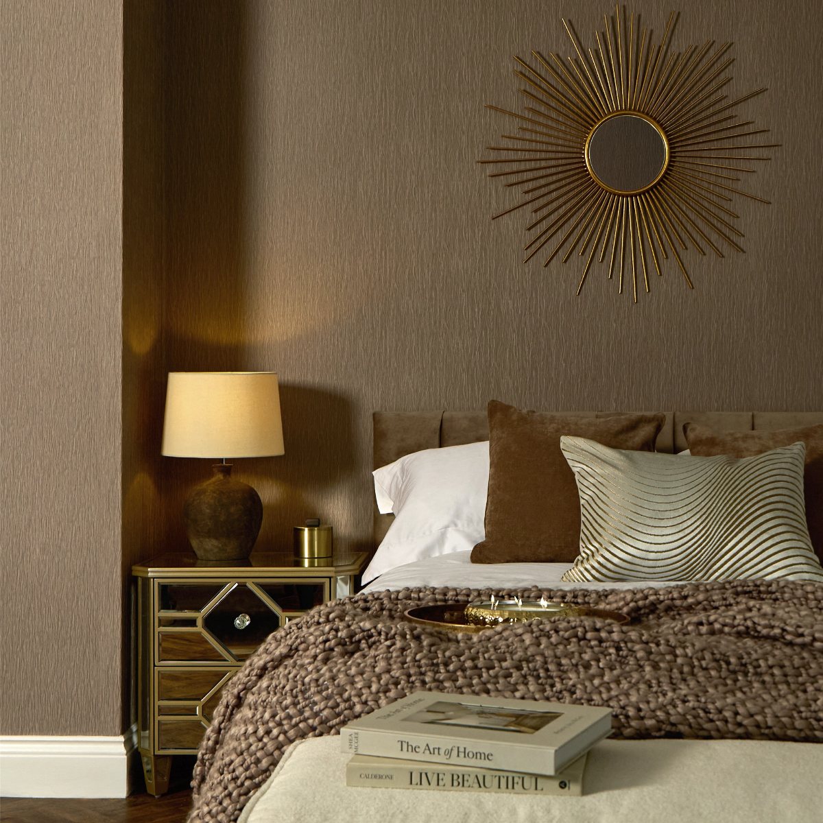 A modern bedroom with neutral furnishings and gold accents.