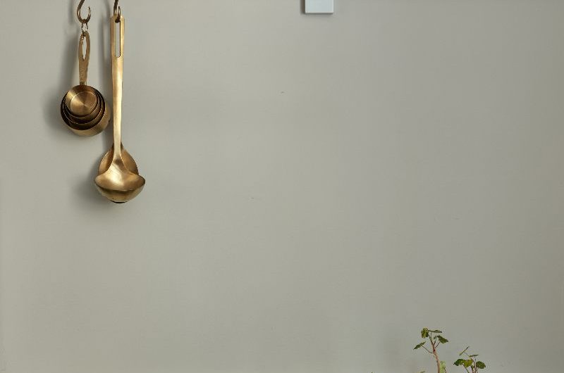A neutral kitchen with marble surfaces, neutral wall paint, and dark cabinets.
