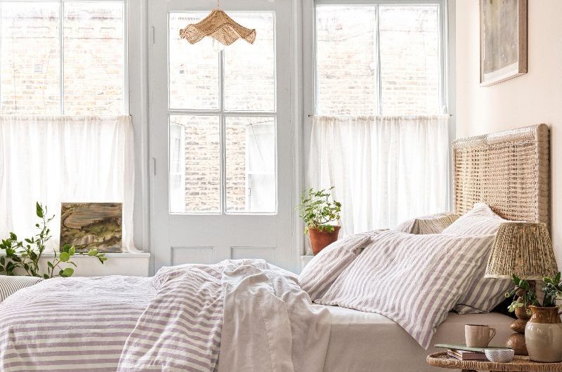 A calm bedroom design with neutral bed linen and organic materials.