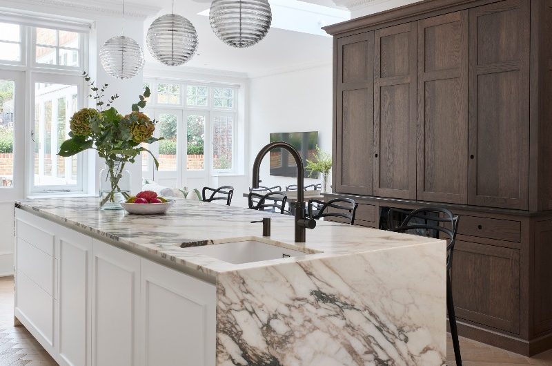 A timeless design with a dark wood dresser and a contrasting white island with bookmatched marble.