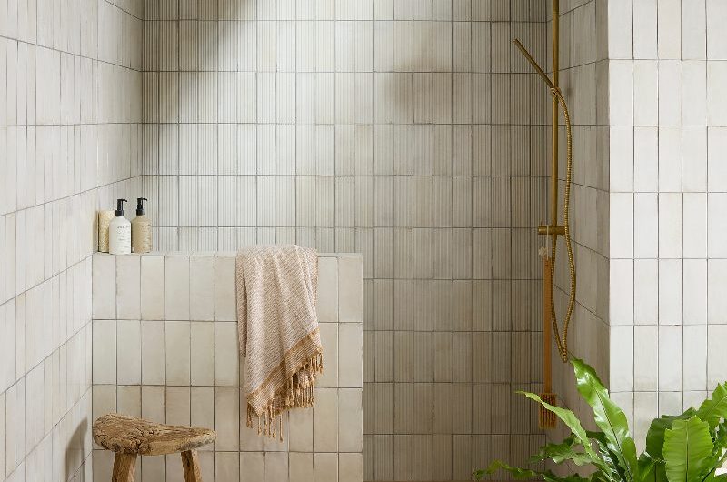 A spa-like bathroom with metro wall slabs, an open shower, and neutral square flooring.