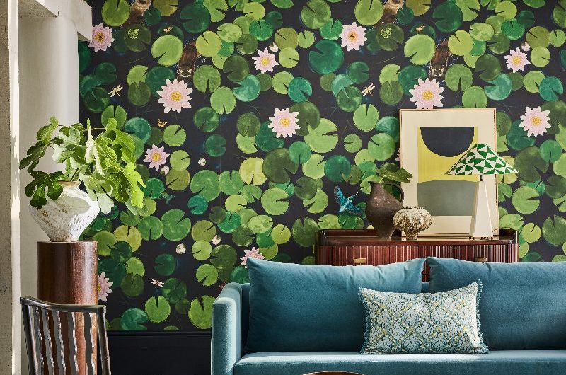 A colourful living room with green and white checkered flooring, a blue sofa, wood furniture, and white beams.