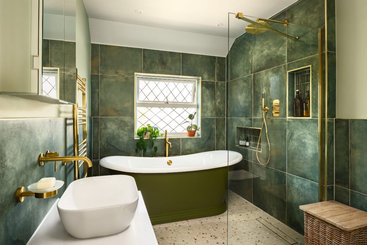 A green wetroom with a shower zone, a green freestanding tub, and a wall-mounted vanity.