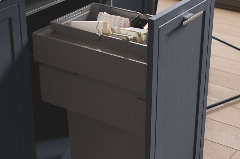 Closeup at a bespoke navy island with a pull-out bin.