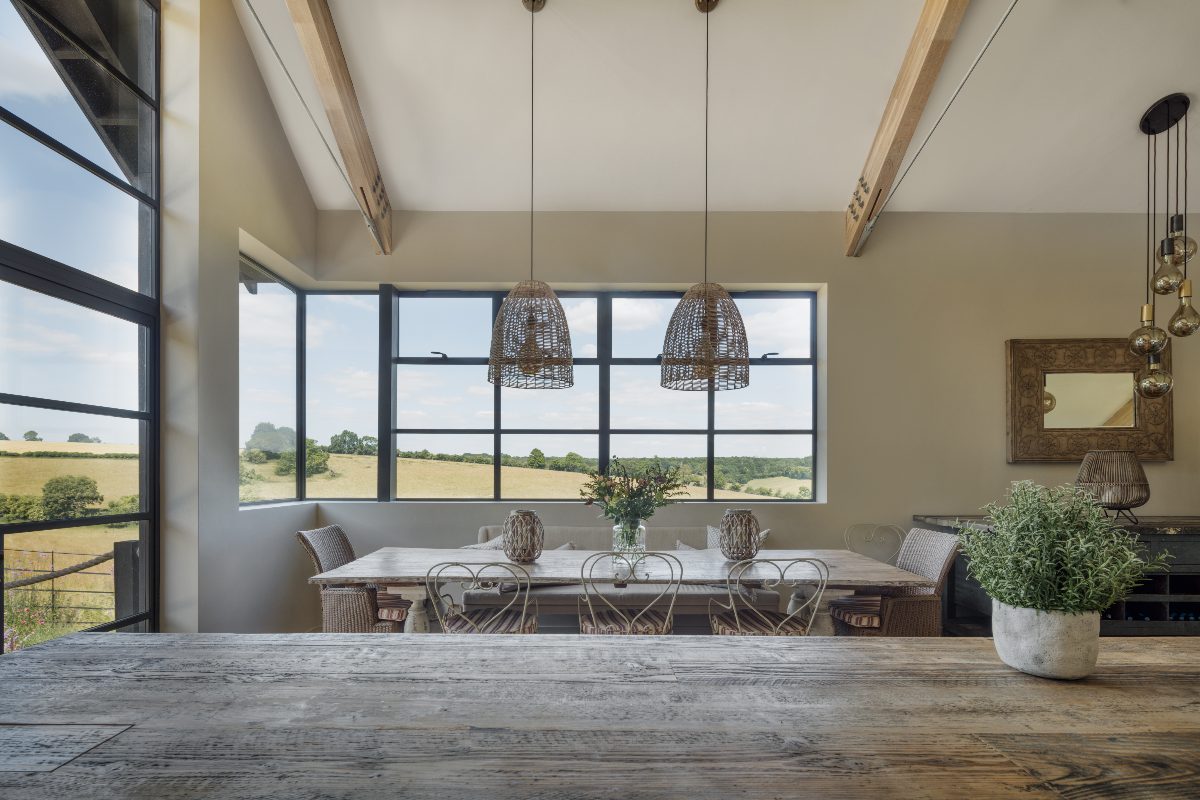 A kitchen-diner with natural materials and a wide expanse of glazing with steel-framed glazing.