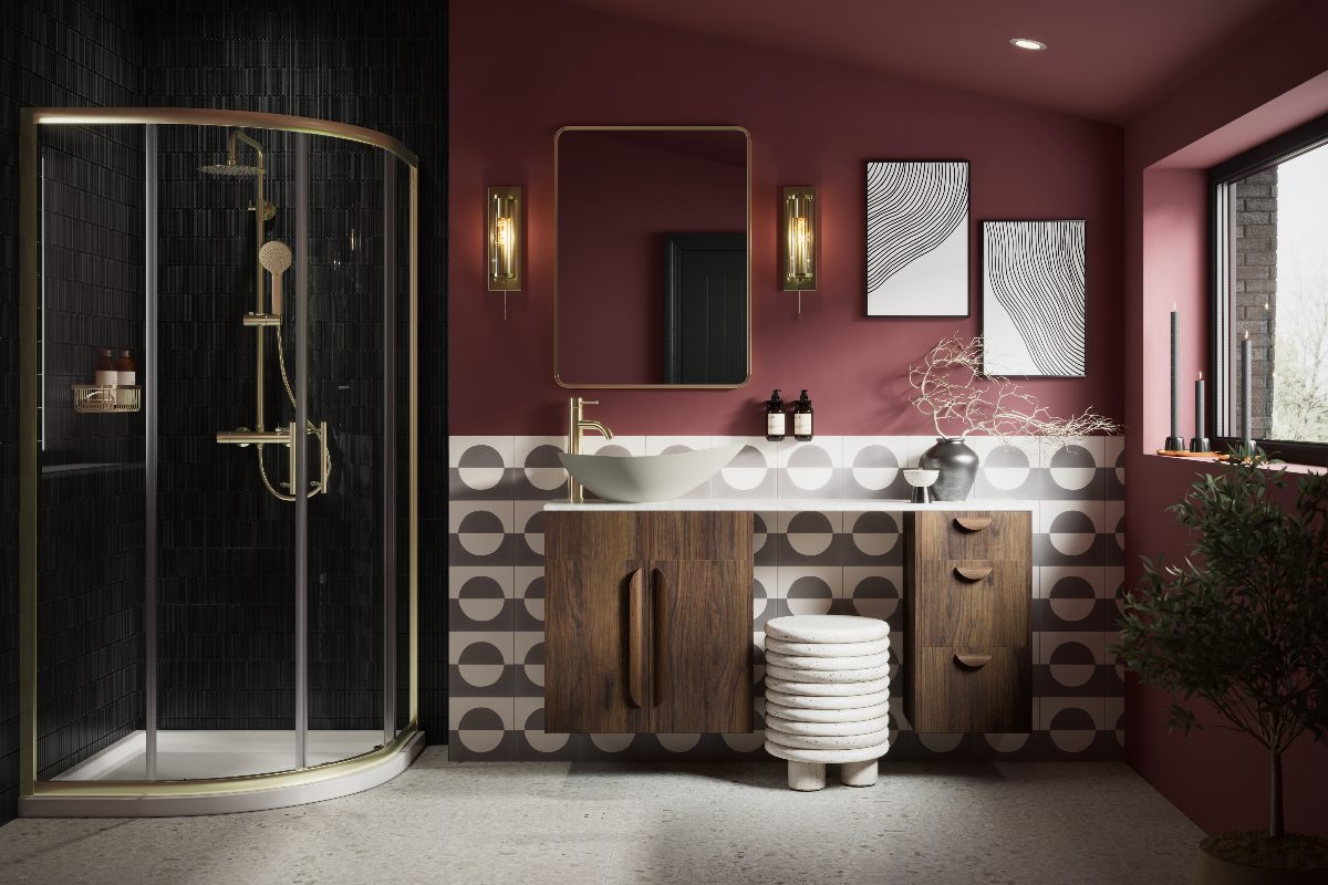 A burgundy bathroom with a distinct vanity zone with geometric tiles and a wood unit, with a dark shower area with a brass enclosure.