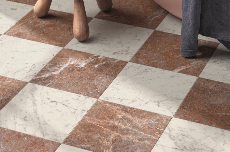 A closeup at checkered tiles in white and red with swirls and veins.