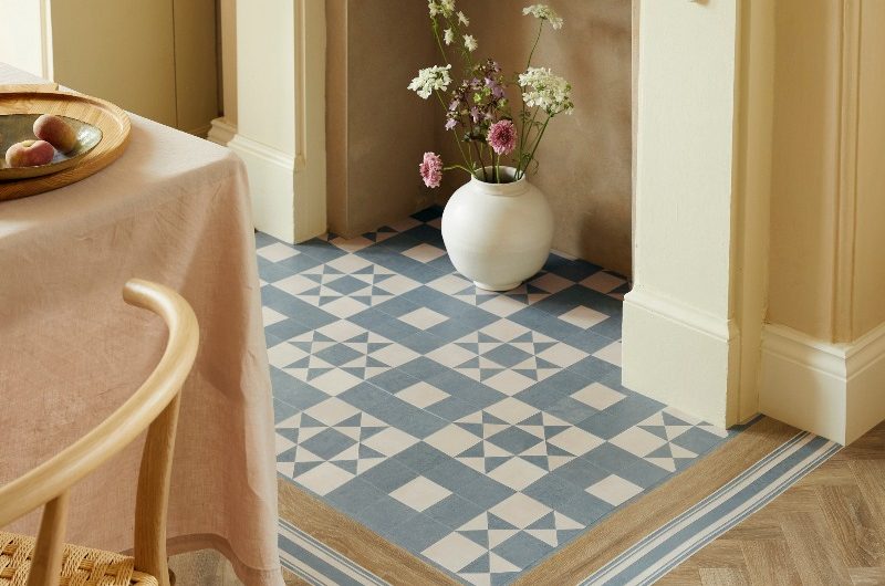 A neutral dining room with a fireplace and a stand-out bordered area around it.