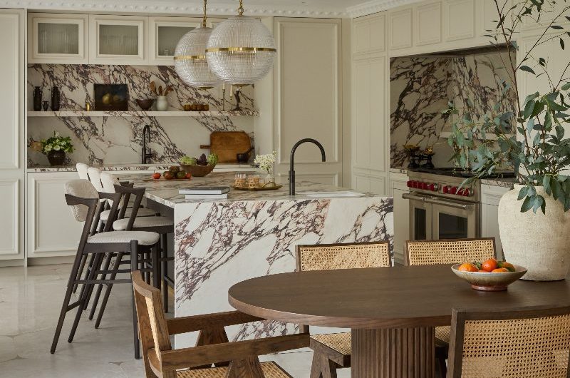 A luxurious kitchen design with decorative cabinetry, waffle glass pendants, porcelain Calacatta Viola work surfaces, a stone-clad island and a fluted walnut dining table.
