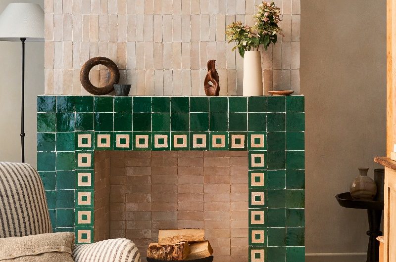 A living space with a striking fireplace decorated with zellige and bejmat tiles and decorative tile borders.