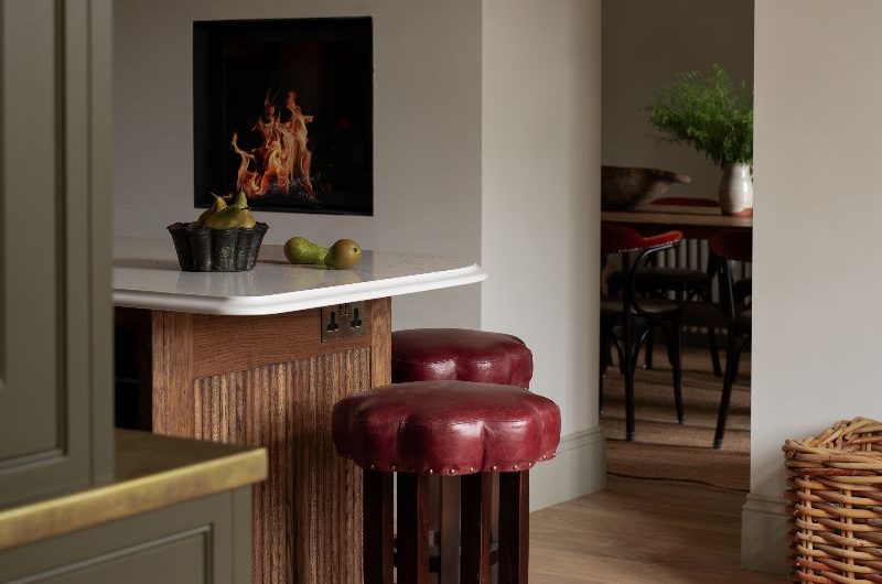 A timeless scheme with a central island with bar-style seating, olive green cabinetry and an adjoining dining room.