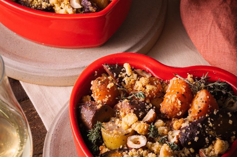 Closeup at red heart-shaped dishes with savoury food on concrete trays.