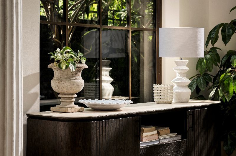 Light-flooded interiors with a large wood sideboard with a curved window and luxurious decor.