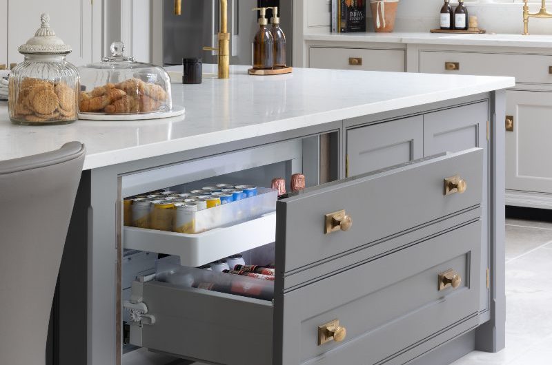 A timeless kitchen island painted in a dark grey with a built-in cool drawer.