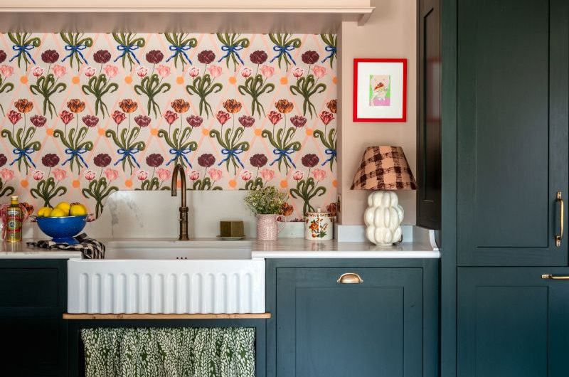 A timeless design with illustrated splashback, a fluted sink, dark green Shaker cabinets, and brass finishes.