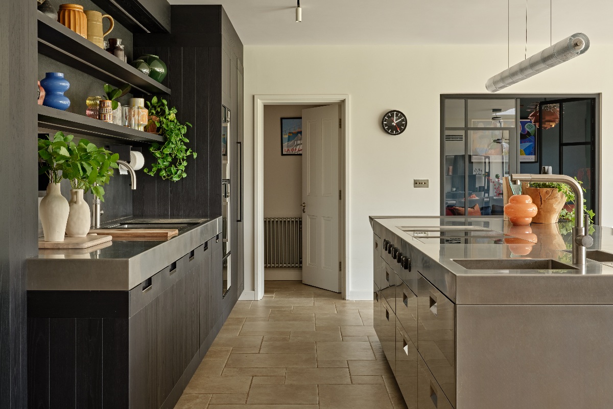 A modern aluminium kitchen with a statement island, a sink run, and stone flooring.