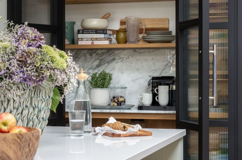A breakfast areas with a coffee station hidden behind fluted doors.