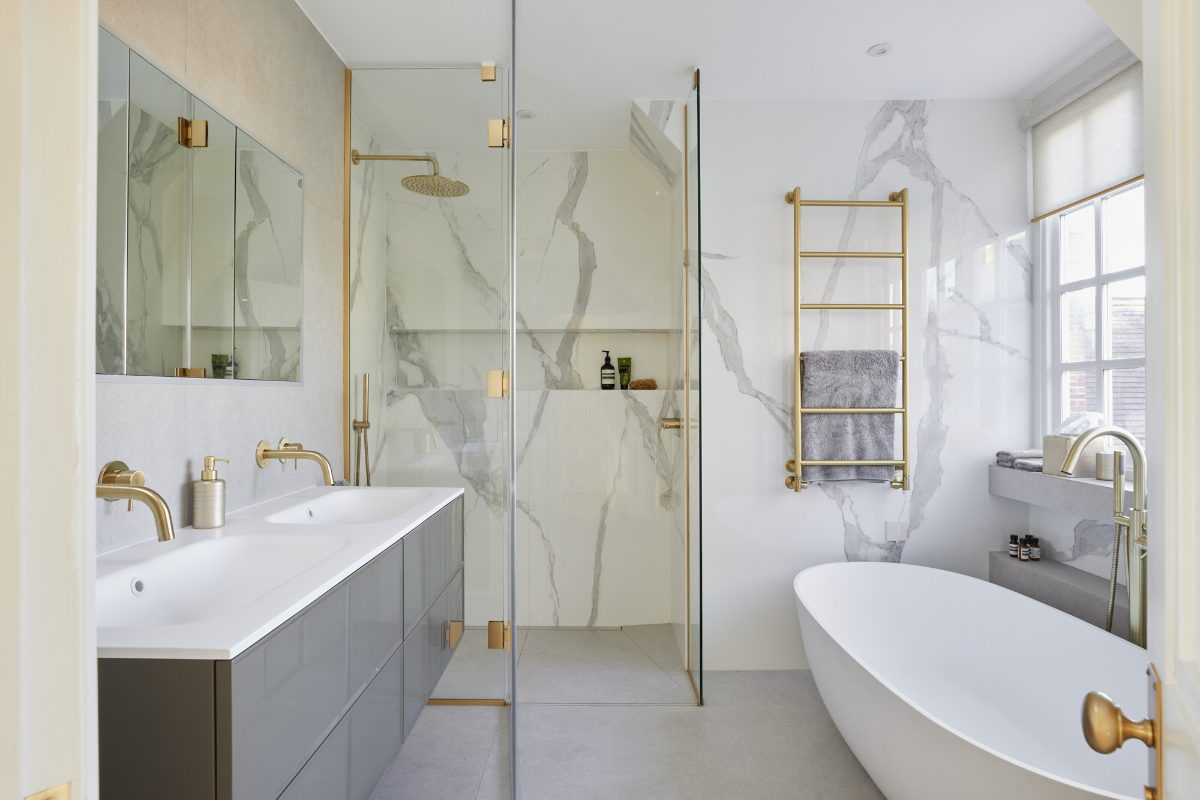 A double vanity with mirrors above it, a shower zone, and a freestanding tub under the window.