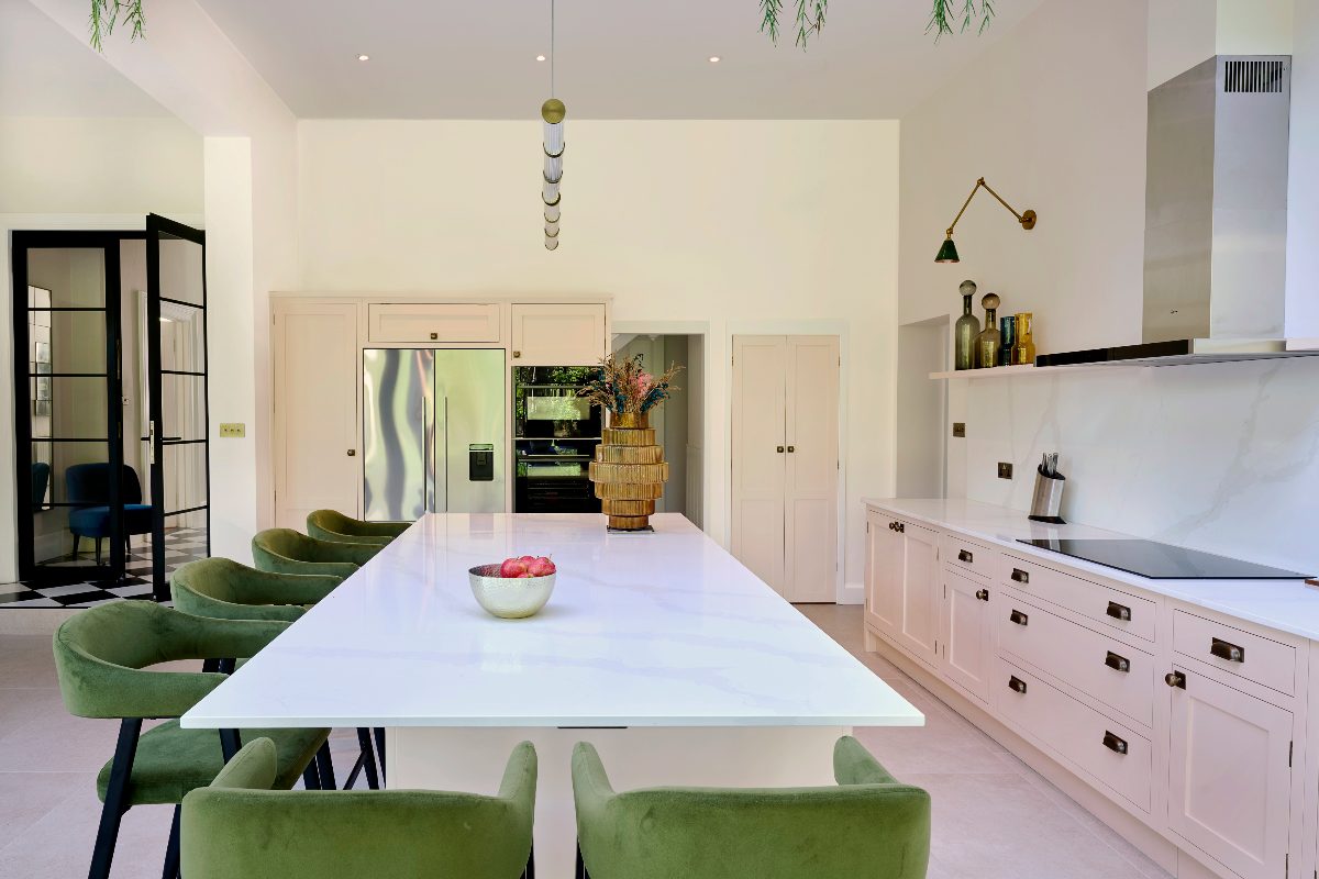 View from the island with green bar stools and a white worktop.