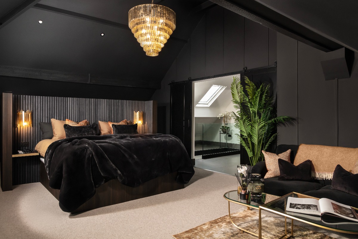 A dark sleep space layered with dark materials and adorned with a range of textures, from velvet to fluted wood.